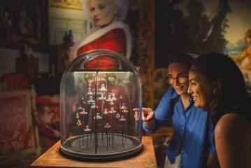 Two people admire jewellery on display at the Vivienne Westwood & Jewellery exhibition.