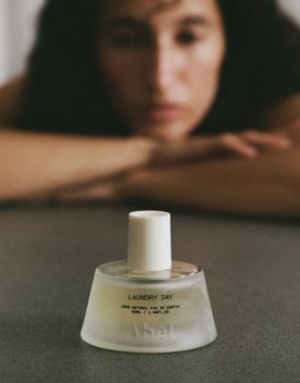 Laundry Day fragrance bottle by Abel Fragrance with an out of focus person in the background