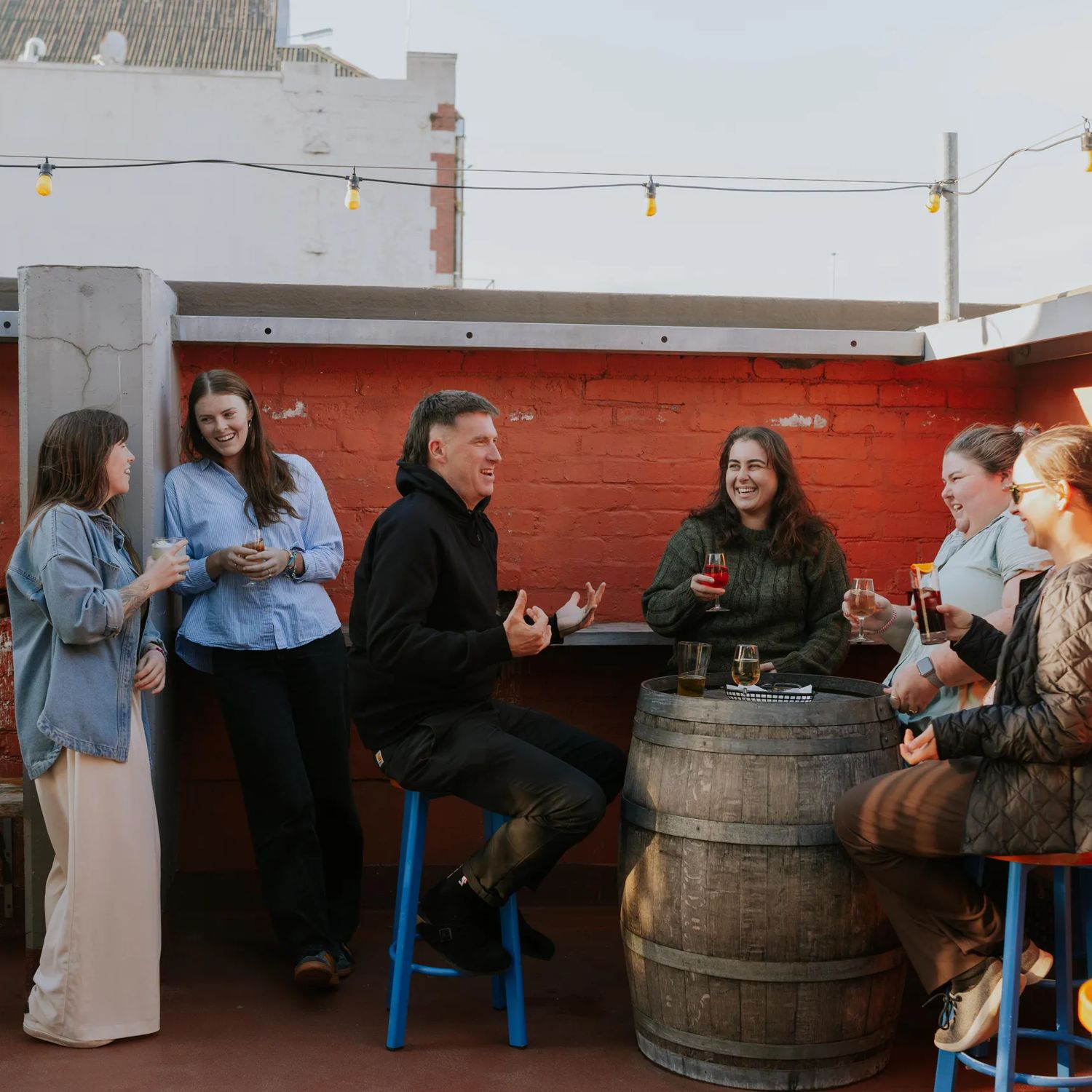 A group of friends enjoy a drink on the rooftop patio at Ascot.