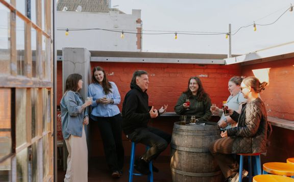 A group of friends enjoy a drink on the rooftop patio at Ascot.