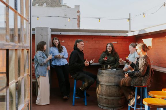 A group of friends enjoy a drink on the rooftop patio at Ascot.