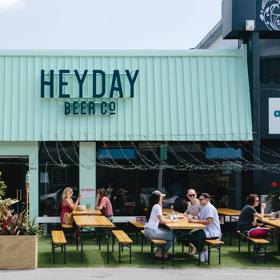 The front facade of Heyday Beer Co. on Upper Cuba Street in Te Aro Wellington. People enjoy drinks at the picnic tables on the front patio.