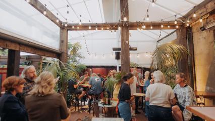Patrons enjoy food and drinks on the covered back patio at Cuba Street Tavern.