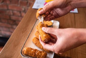 Mozzarella sticks being pulled apart.