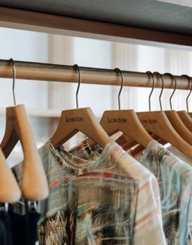 A clothing rack with a variety of tops hanging at Kowtow.