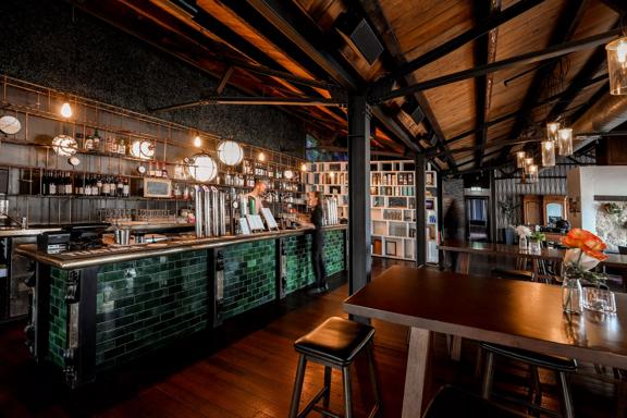 Two workers on either side of the bench inside Foxglove Bar & Kitchen.