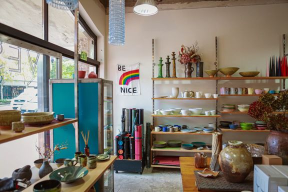 Inside Vessel gift shop, we can see a large variety of dinnerware on the shelves.