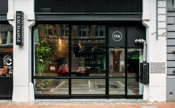 The exterior of The Exchange on Allen Street has white concrete columns with large windows.