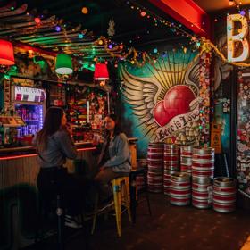 Two people enjoying drinks at Golding's Free Dive, a cool, kitsch, and cosy laneway bar in Te Aro, Wellington.