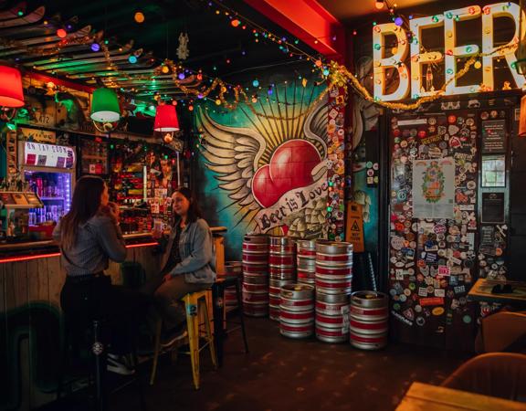 Two people enjoying drinks at Golding's Free Dive, a cool, kitsch, and cosy laneway bar in Te Aro, Wellington.