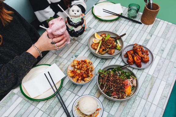 Shared Asian-style dishes and drinks served on a marble table.