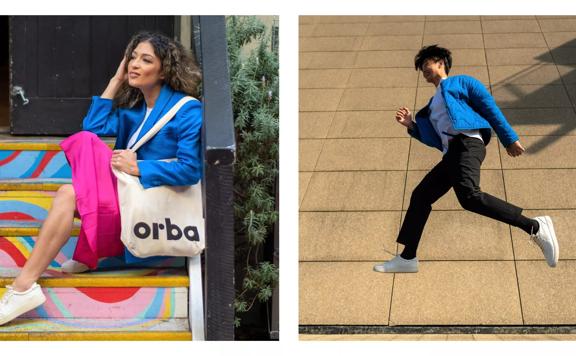 Composite of two images. Woman sits on colourful steps, wearing a blue blazer, bright pink skirt, white sneakers and an Orba tote bag (left). Man jumping in a running man position, in front of a beige stone facade, wearing a blue jacket and white Orba sne