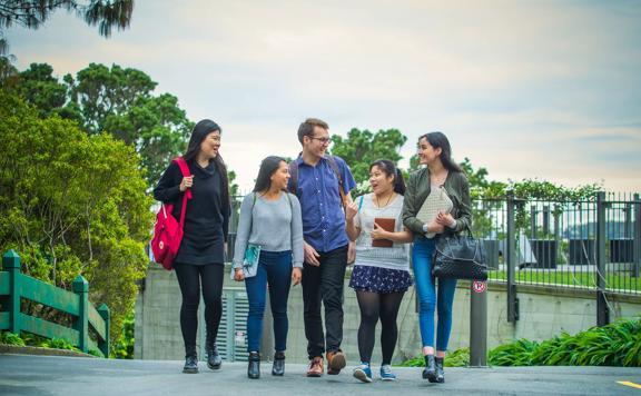 Five students are walking together on Victoria University campus in Kelburn, Wellington.