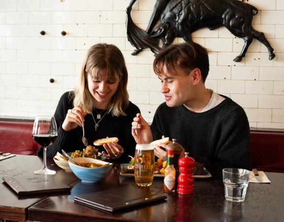 Two people enjoy food and drinks at El Matador.