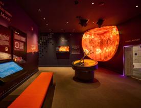 One of the exhibition rooms in Wellington's Space Place with a model of the sun, informative plaques and interactive screens.