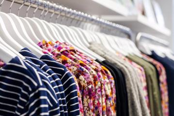 A rack of clothing on white hangers in Wilson Trollope.