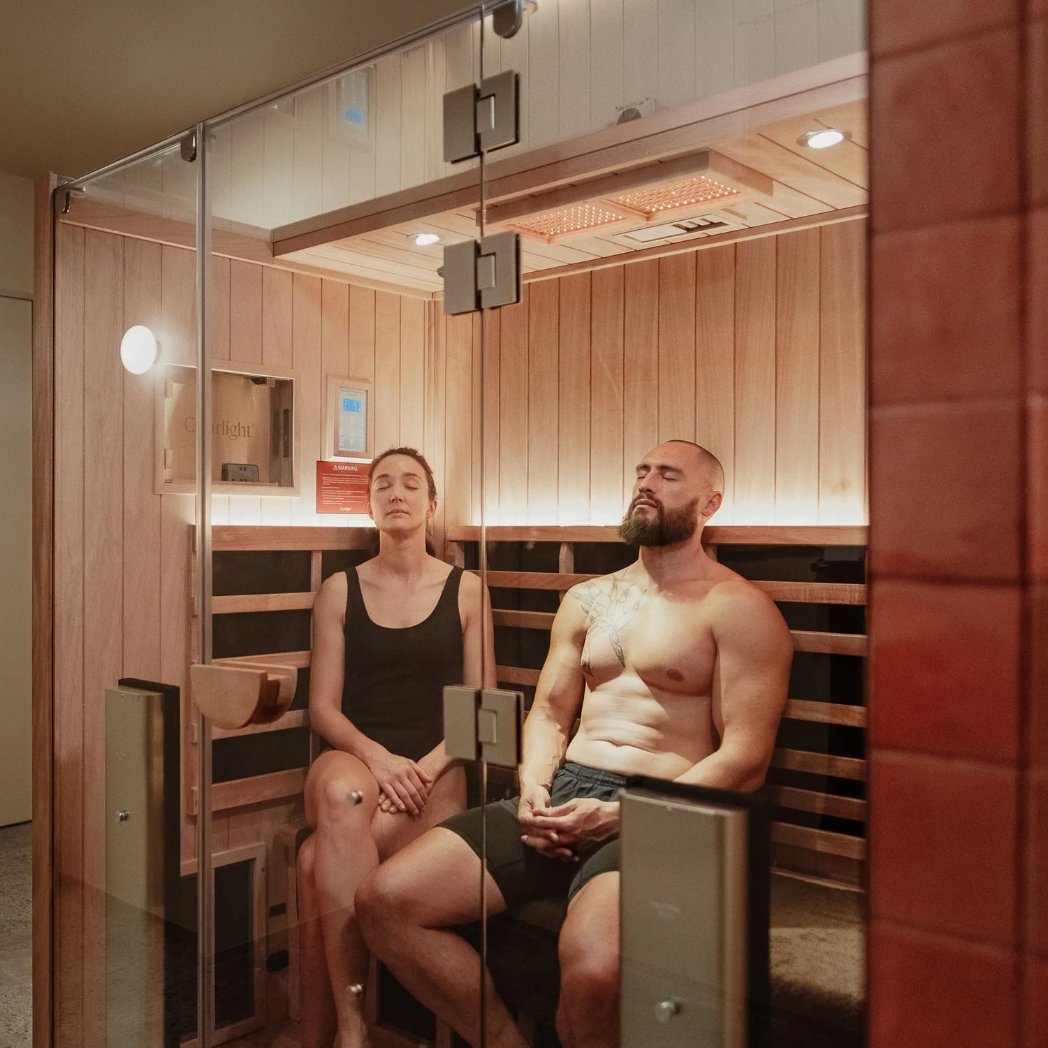 Two people inside a Numa Skin Club sauna are relaxing.