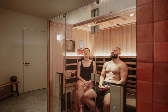 Two people inside a Numa Skin Club sauna are relaxing.