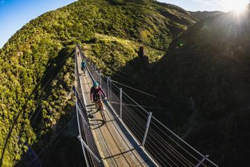 2 bikers going over the Siberia Gully bridge, on the Rail Trail Section on the Remutaka Cycle Trail.