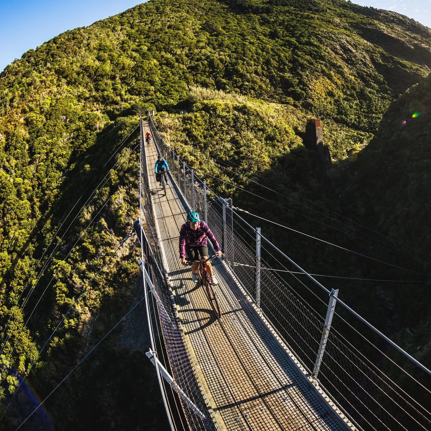 2 bikers going over the Siberia Gully bridge, on the Rail Trail Section on the Remutaka Cycle Trail.