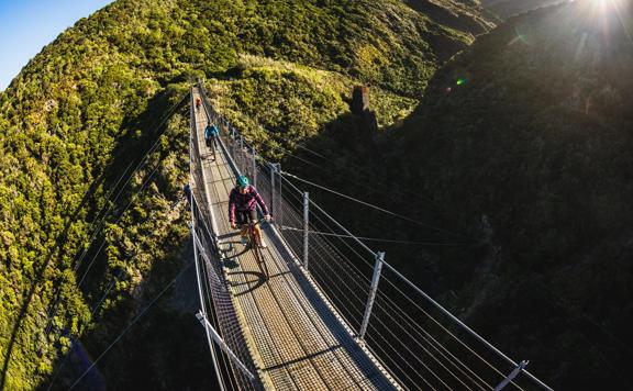 2 bikers going over the Siberia Gully bridge, on the Rail Trail Section on the Remutaka Cycle Trail.