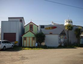 The Petone boat ramp, Hikoikoi,  with colourful boat sheds and boats in the morning sun.