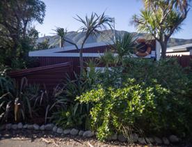 The Petone boat ramp, Hikoikoi,  with colourful boat sheds and boats in the morning sun.