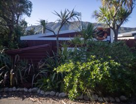 The Petone boat ramp, Hikoikoi,  with colourful boat sheds and boats in the morning sun.