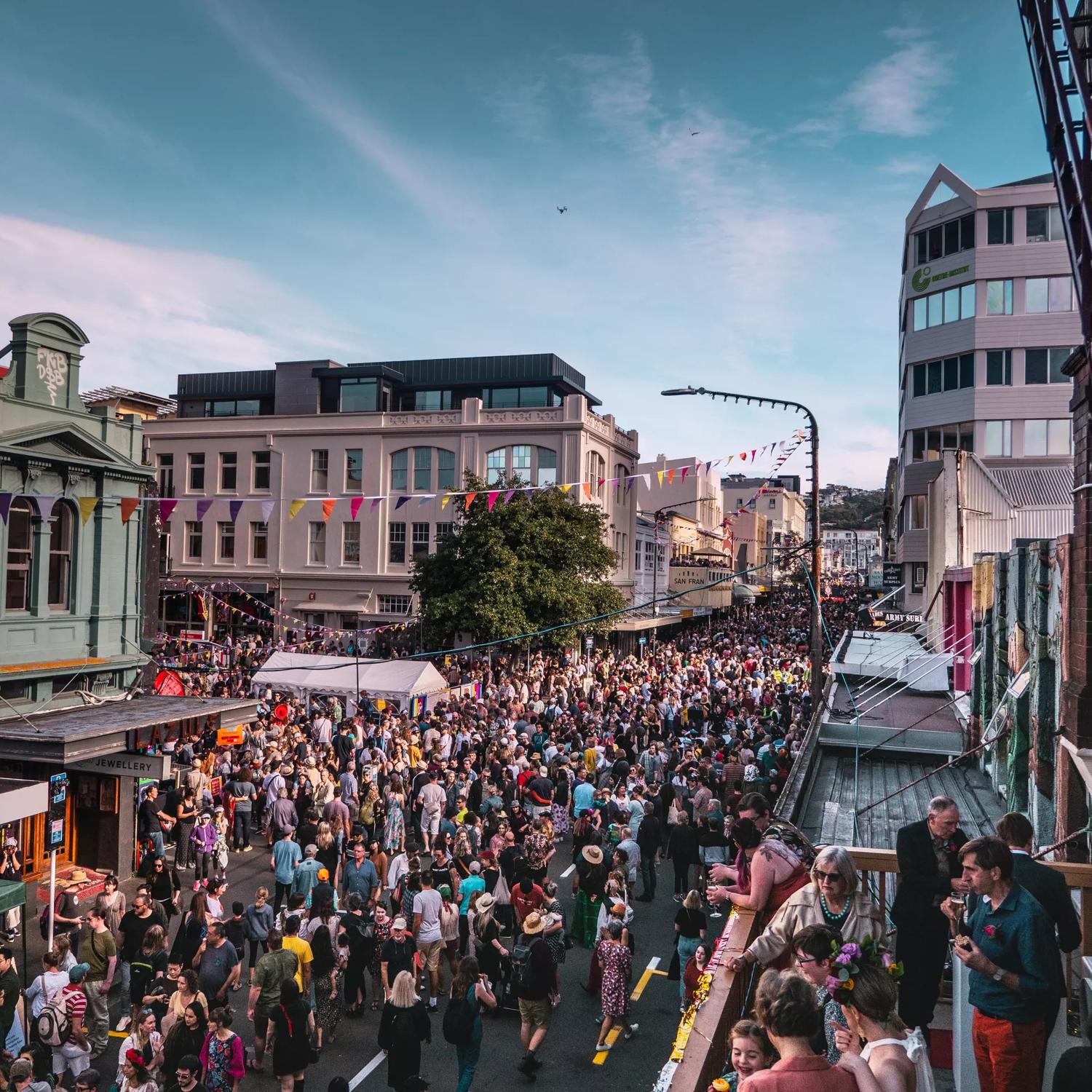 Looking down on Cuba street as hundreds of people flood the street for CubaDupa wearing bright colours.