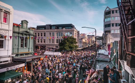 Looking down on Cuba street as hundreds of people flood the street for CubaDupa wearing bright colours.