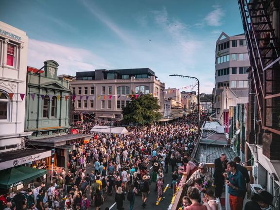 Looking down on Cuba street as hundreds of people flood the street for CubaDupa wearing bright colours.