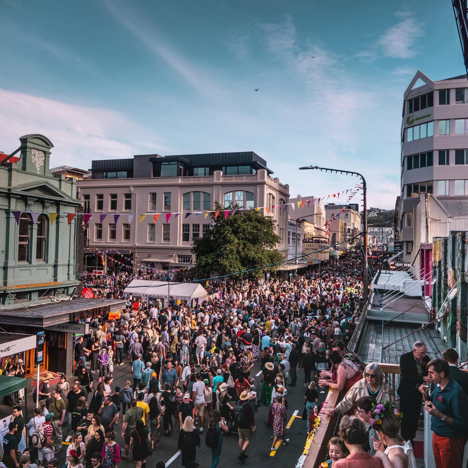 Looking down on Cuba street as hundreds of people flood the street for CubaDupa wearing bright colours.
