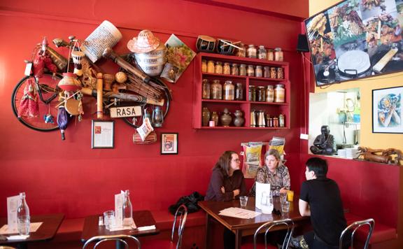 Three people sit together at the corner booth table at Rasa Malaysian.