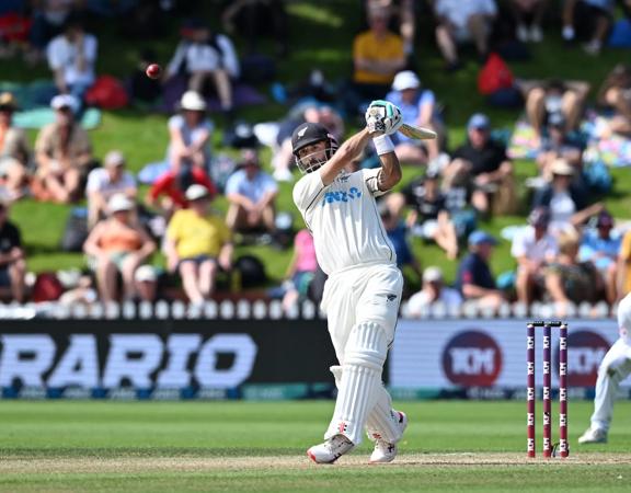 A cricket player swings the bat during a match.