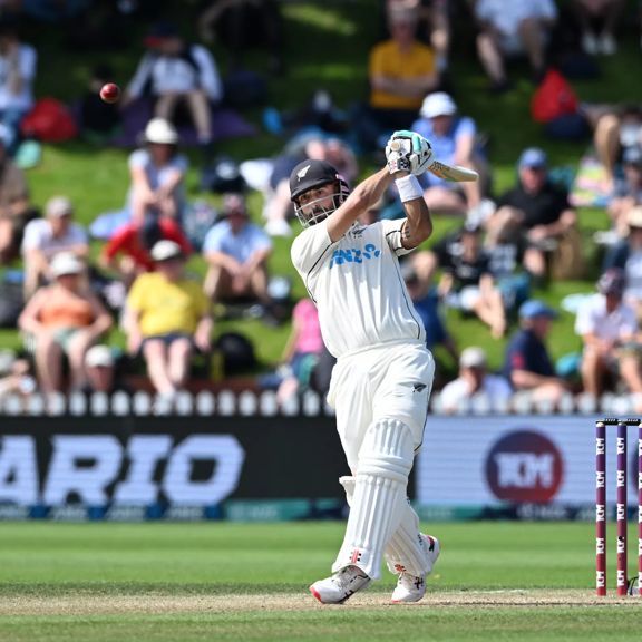 A cricket player swings the bat during a match.