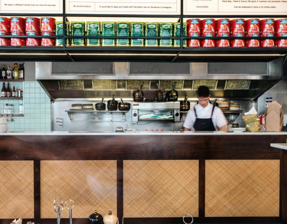 A chef working in the kitchen at 1154 Pastaria on Cuba Street.