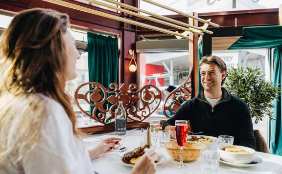 Two friends enjoy French food and drinks at Le Bouillon Bel Air.