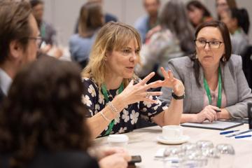 Four people sit at a table at the Life Sciences Summer 2024 at Tākina Wellington Convention and Exhibition Centre.