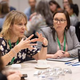 Four people sit at a table at the Life Sciences Summer 2024 at Tākina Wellington Convention and Exhibition Centre.