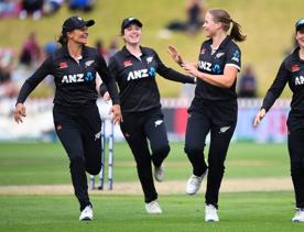 Four WHITE FERNS cricket players running on the pitch.