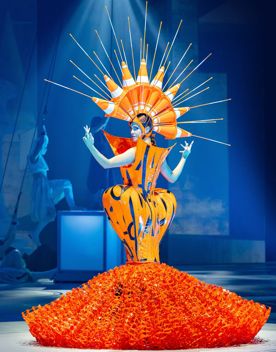 World of WearableArt design Curves Ahead by Grace DuVal from the United States is an orange dress with exaggerated proportions made of road works plastic and cones.