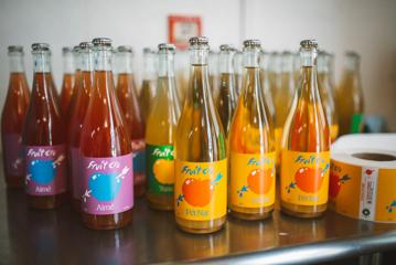 Bottles of Fruit Cru on a stainless steel table.