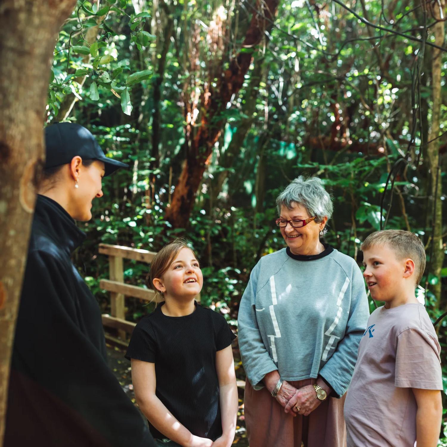 Two kids and an adult are on a guided walking tour at Zealandia.