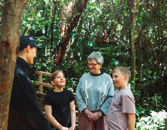 Two kids and an adult are on a guided walking tour at Zealandia.