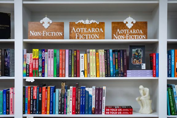 Books on display at Aurelia Books, arranged on white shelves beneath non-fiction and fiction signs.