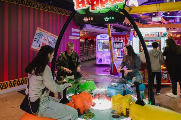 Three people play Hungry Hungry Gippo in Holey Moley, the mini golf course and bar at Willis Lane.