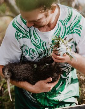 Person holding a Kiwi bird