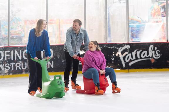 A group of people ice skating at Daytona Adventure Park in Upper Hutt, supporting themselves with two dolphin skate assists.