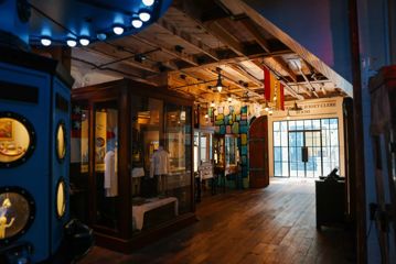 Historical items on display at the Wellington Museum. It's a dimly lit space with hardwood floors and exposed beams on the ceiling.