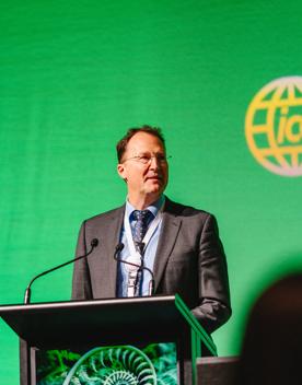 Person speaking on stage at the ICDE World Conference, at Tākina Wellington Convention and Exhibition Centre